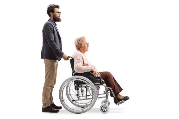 projectile complet de profil de longueur d’un homme barbu poussant une dame âgée assise dans un fauteuil roulant - physical injury men orthopedic equipment isolated on white photos et images de collection