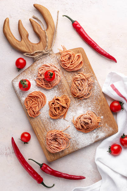 spaghetti fatti in casa con pepe e pomodoro su tavola di legno su sfondo leggero in cemento, vista dall'alto - 6726 foto e immagini stock