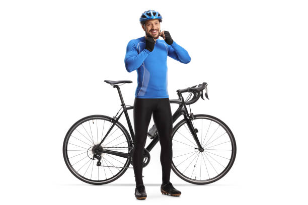 Male cyclist putting on a helmet and smiling next to his bicyclE Full length portrait of a male cyclist putting on a helmet and smiling next to his bicycle isolated on white background biker photos stock pictures, royalty-free photos & images