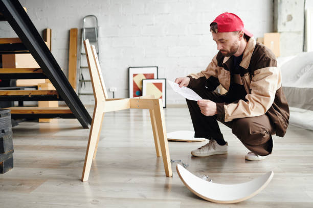 istock Young furniture assemblage specialist standing on squats and looking through instruction on paper 1313162349