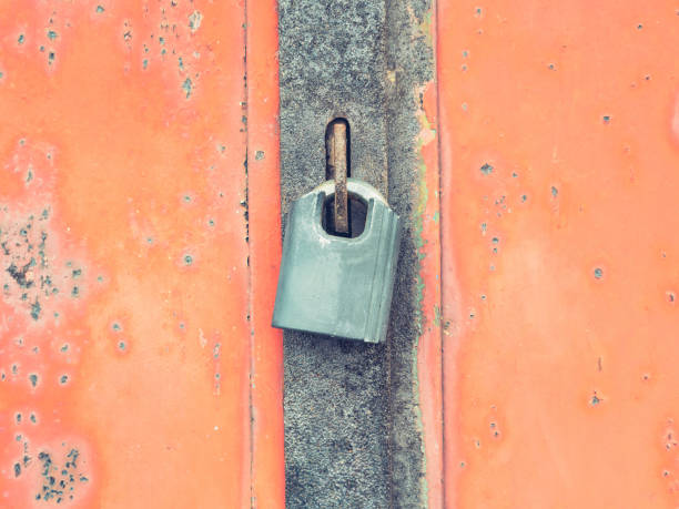 le cadenas pendent dans l’oeil de boulon de la porte en métal rouge. style de porte vintage. - eye bolt photos et images de collection