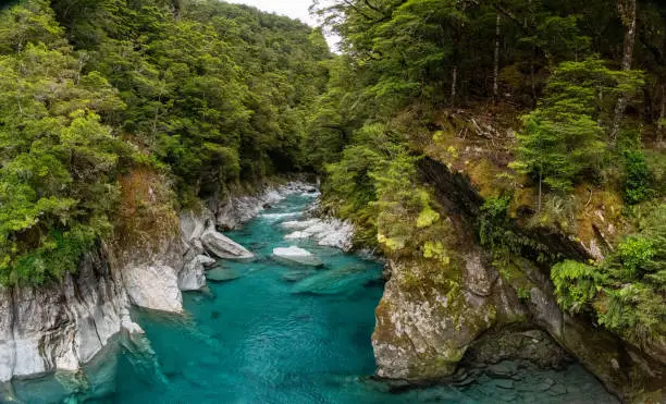 Photo of Colorful blue mountain river at the Haast pass, New Zealand