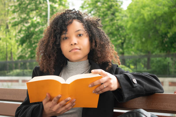 istock Woman with a book on her hands and looking to camera. 1313167820