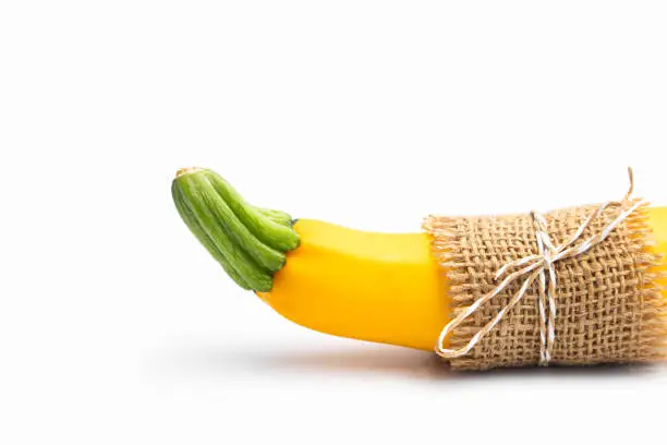 Photo of Packed Summer Squash Zucchini, Yellow Colored Gourd Also Known As Courgette, Baby Marrow, Indian Jugni Sabzi Or Jugnu Petha Sabji Tied In Burlap Cloth. Isolated On White Background And Copy Space