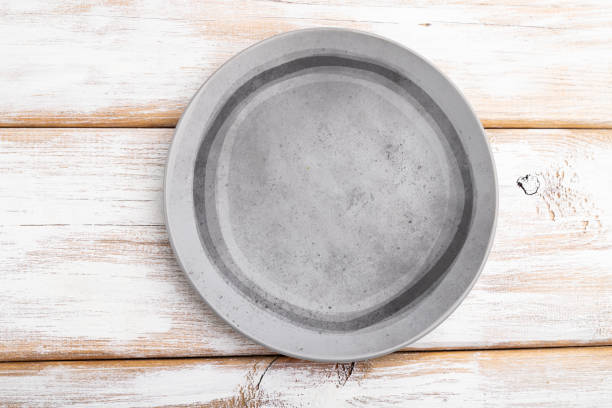 istock Empty gray ceramic plate on white wooden background. Top view, close up, flat lay. 1313170216