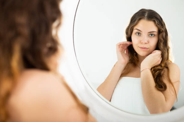 istock Young long-haired girl admiring her reflection in mirror 1313170910