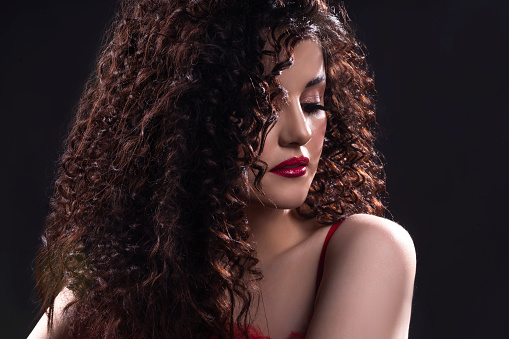 curly hair young woman. gray background