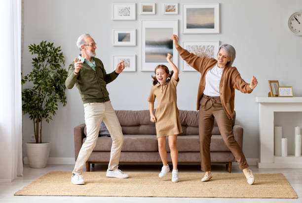 podekscytowana dziewczyna w wieku przedszkolnym bawiąca się z aktywnym pozytywnym dziadkiem - family grandmother child happiness zdjęcia i obrazy z banku zdjęć