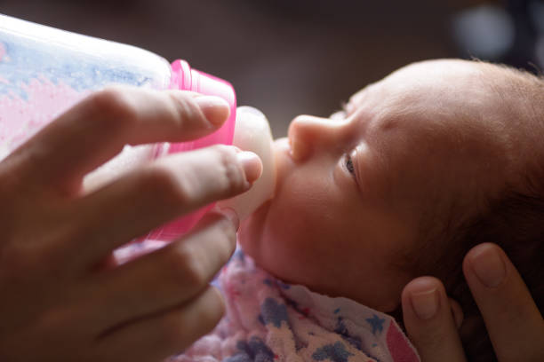 Mother feeds the newborn with bottle milk Mother feeds the newborn with bottle milk formula stock pictures, royalty-free photos & images