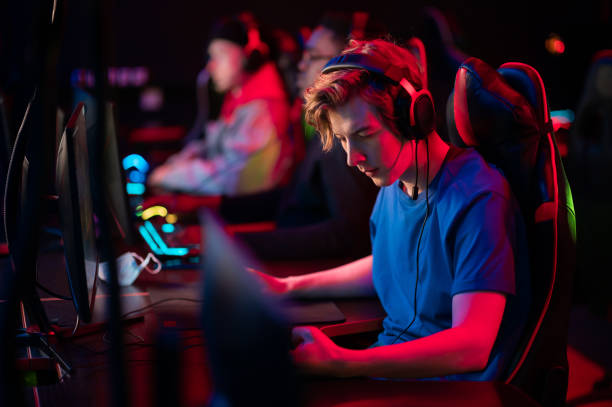 treinamento bootcamp para jogadores profissionais de esports. jovens ciber-atletas jogam um jogo de tiro online. teclado brilhante, luz neon - gaming systems - fotografias e filmes do acervo