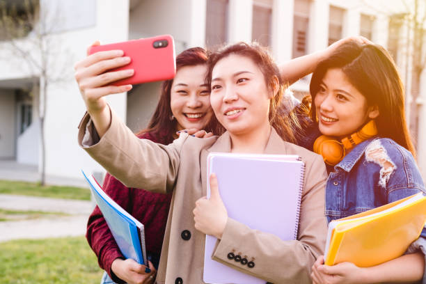 istock Asian college students taking a selfie with a mobile phone while standing outside the university campus. Education concept. 1313182689