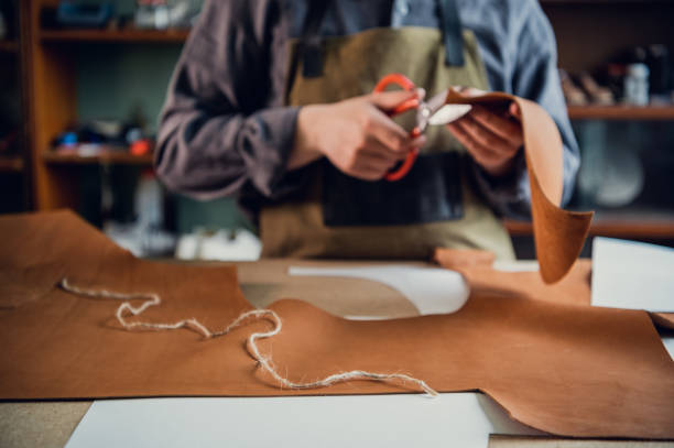istock A young tanner in his workshop at the table cuts out leather elements of shoes 1313183632