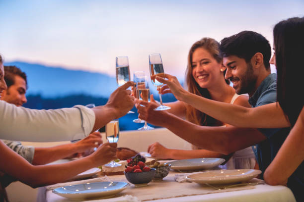 日没時にシャンパンで乾杯する友人のグループ - champagne toast wine restaurant ストックフォトと画像