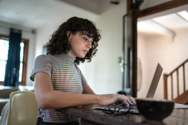 istock Transgender woman using laptop working at home 1313191088