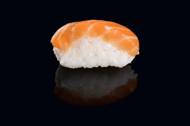 niguiri salmón aislado sobre fondo negro - niguiri sushi fotografías e imágenes de stock