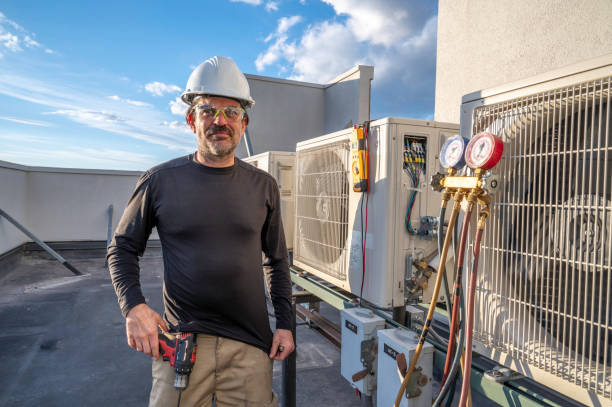 HVAC technician standing next to mini split ac's stock photo