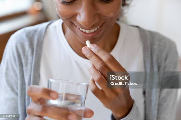 Close Up Happy Young African American Young Woman Taking Vitamins Stock Photo - Download Image Now