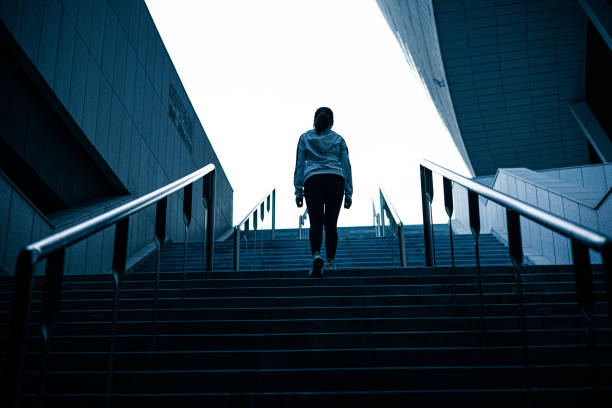 istock Young woman walking up stairs 1313215686