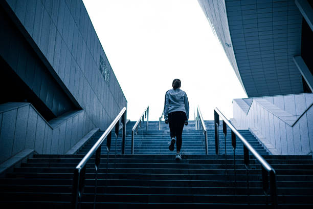 istock Young woman walking up stairs 1313215771