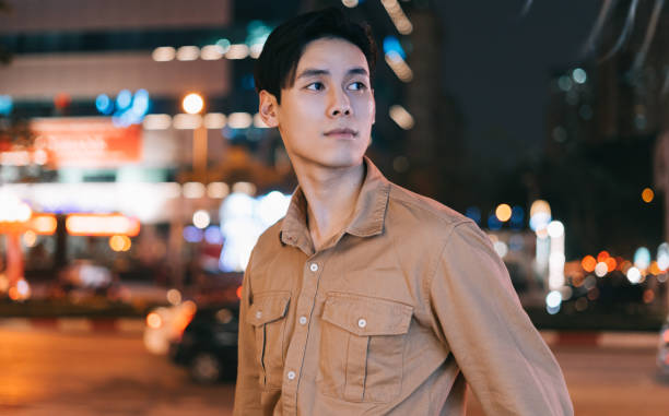 Asian man is walking in the street at night feeling lost