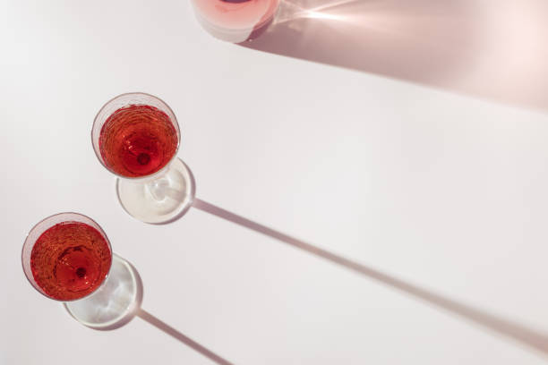 istock Rose wine in bright crystal glasses, rose champagne sparkling wine with daylight shadows. Summer alcoholic drink 1313216596