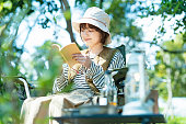 屋外で本を読む若い女性