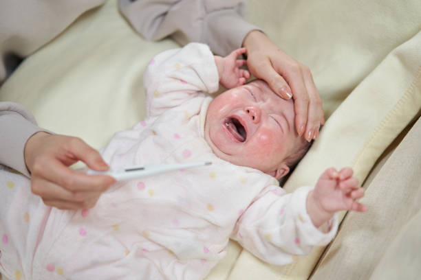 bimbo asiatico che piange con la febbre - child fever illness thermometer foto e immagini stock