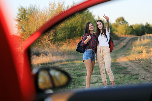 Girls having a road trip with a car