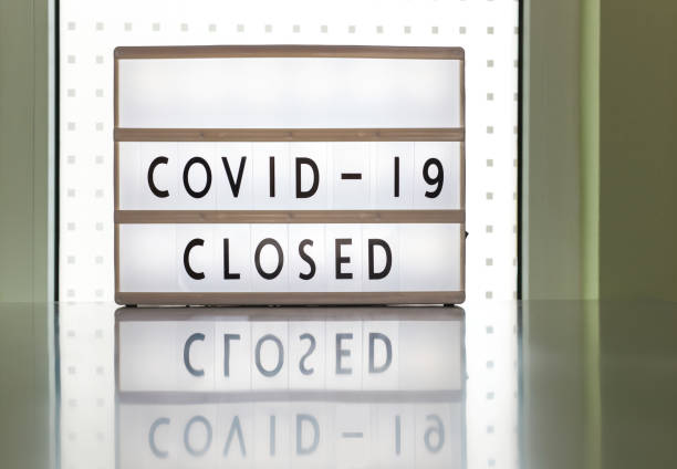 istock COVID-19 Closed, prevention message on white sign. Government mandatory shutdown order of restaurants, non essential stores or curfew forcing closure of businesses leading to unemployment. 1313224651