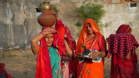 08 April 2021- Reengus, Sikar, India.Religious females group with Clay pot and sacred worship plate. Traditional women in Hindu cultured saree.
