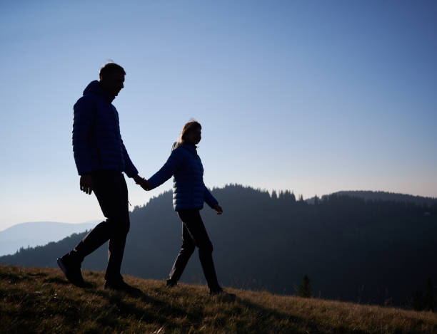 istock Young married pair walking in mountains at noon in sunny day. 1313227085