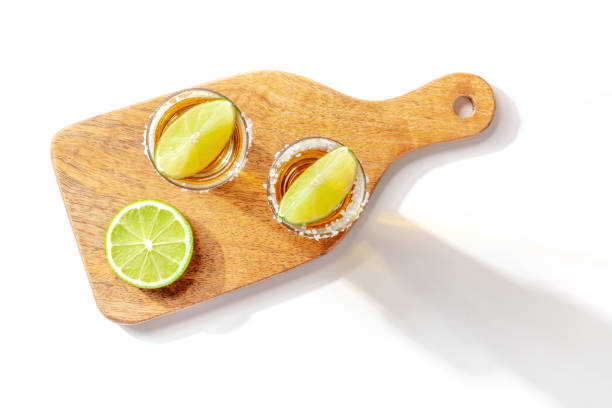 istock Tequila shots served on a wooden board with lime slices 1313227265