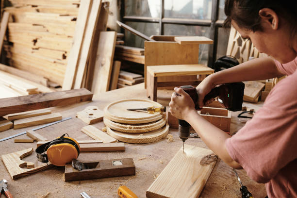 istock Woman drilling wooden board 1313229182