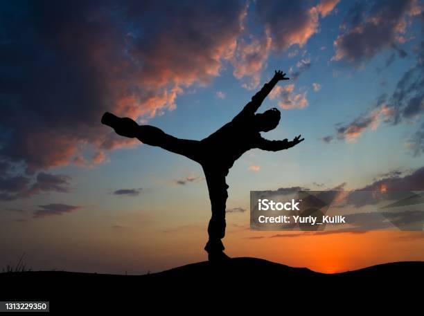 Man Doing An Exercise On A Evening Sky Background Stock Photo - Download Image Now - Adult, Blue, Bright