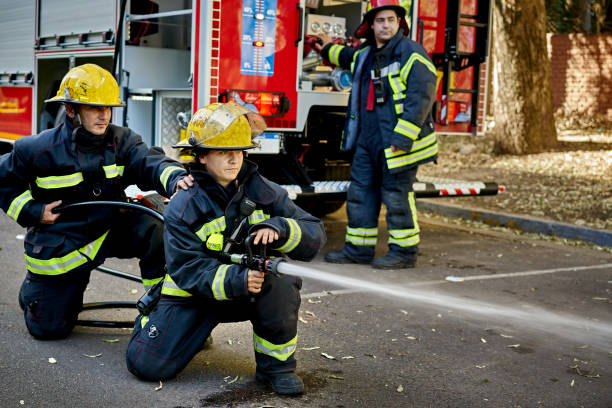 istock Mid Adult Firefighting Hose Team in Kneeling Position 1313232177