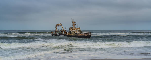 Skeleton Coast in Namibia. The shipwreck was stranded or grounded at the coastline Skeleton Coast in Namibia. The shipwreck was stranded or grounded at the coastline of the Atlantic close to Swakopmund, Panorama swakopmund photos stock pictures, royalty-free photos & images