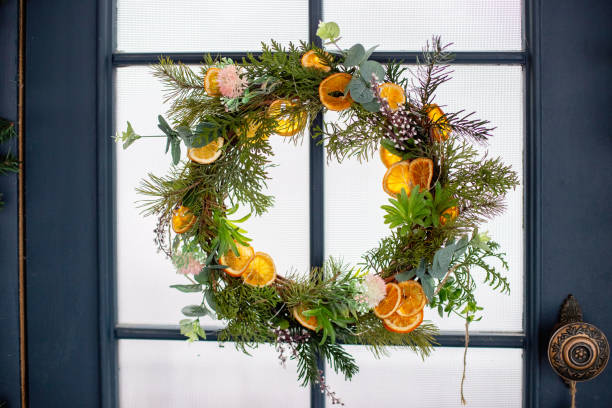 Creative xmas wreath of pine branches, cones and citrus.