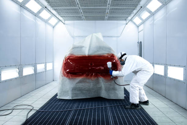 istock Car painter varnishing vehicle in painting chamber workshop. 1313236995
