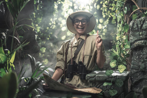Cheerful woman exploring a tropical jungle with a map, she finds some ancient ruins