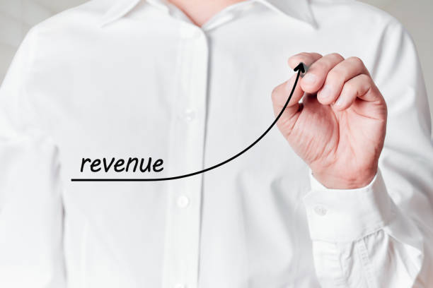 istock Businessman with a pen draws a rising line graph with the word revenue on a virtual screen. Business revenue increase 1313242529