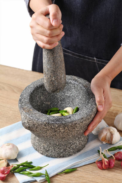 istock Woman use stone Mortar and Pestle for cooking green curry paste in kitchen 1313243748