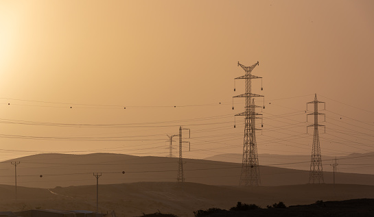 Power lines in distant hills against dawn