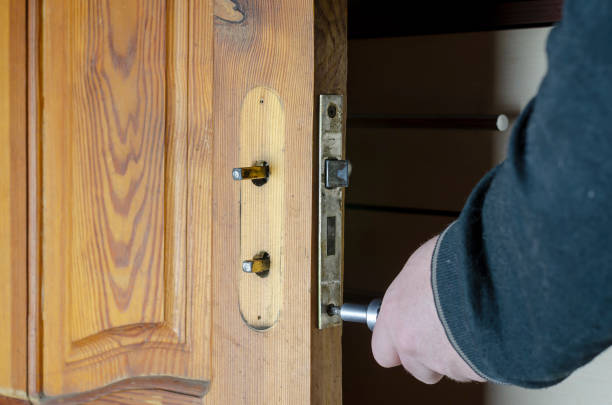 A man removes the old door lock. A man removes the old door lock. Hands with a screwdriver unscrew the mounting screws of the mortise lock of a wooden interior door. Services to repair or replace furniture fittings. Indoors door chain stock pictures, royalty-free photos & images
