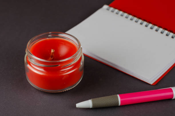 istock Red candle, open blank notebook and pen on gray background. 1313246929