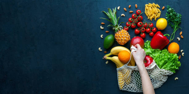 istock Human hand holding a string bag with fruits and vegetables 1313247051