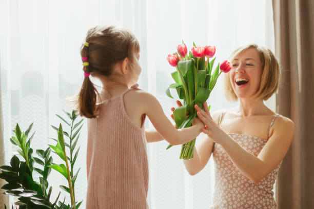 母の日を祝う小さな女の子 - bouquet mothers day tulip flower ストックフォトと画像