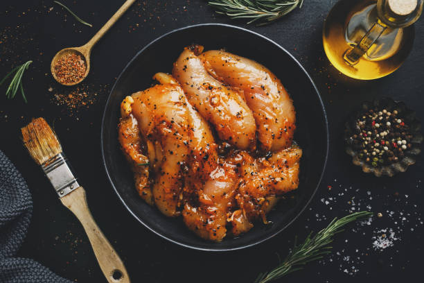 istock Raw marinated chicken breast on dark background with spices ready to cook. 1313249364