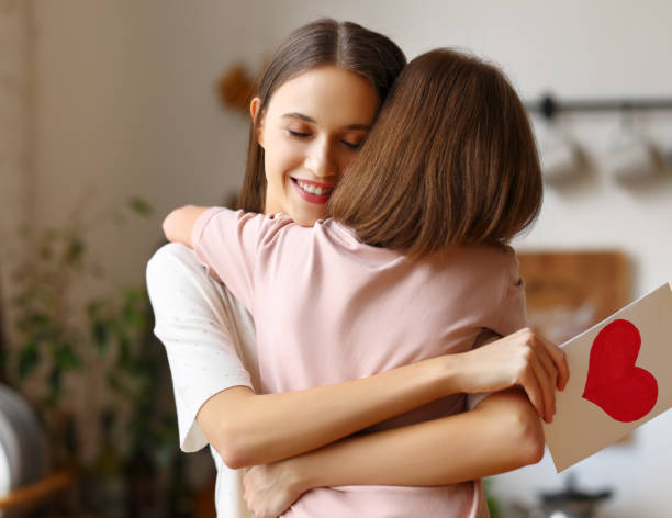 istock Young mother with greeting card embracing daughter 1313249651