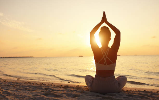 istock Calm woman meditating on beach at sunset 1313250535