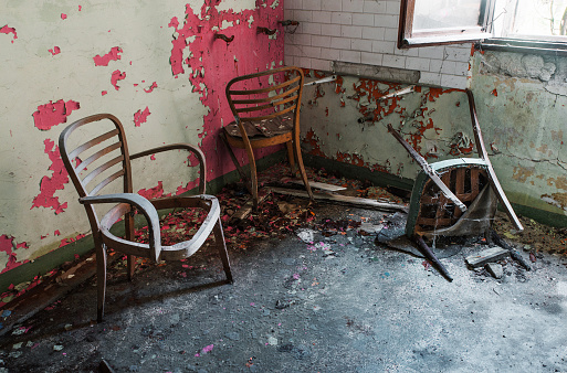 Old and broken wooden chairs in abandoned hospital